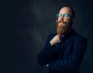 Hombre calvo con barba y bigote en fondo oscuro