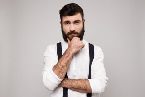 Hombre con barba bien cuidada en fondo gris claro